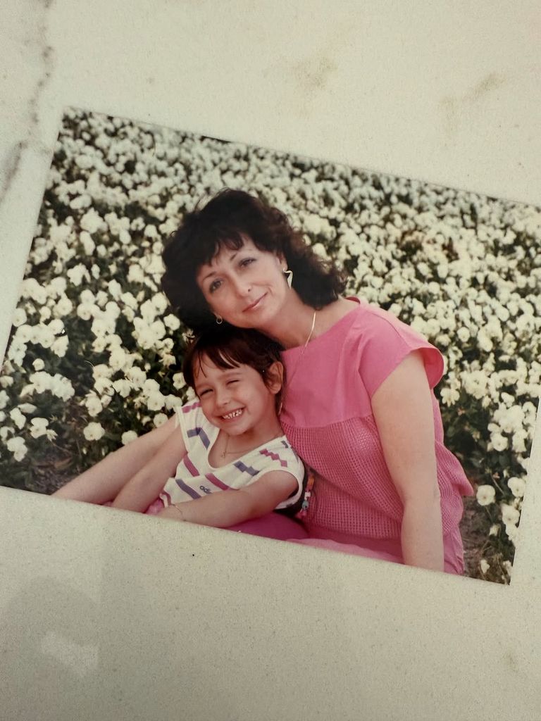 Jennifer Love Hewitt as a young girl sits with her mom in a field of flowers