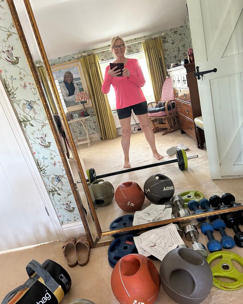 Fern mirror selfie in shorts and pink gym top