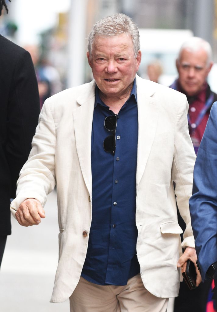 William suit, sunglasses, walking NY