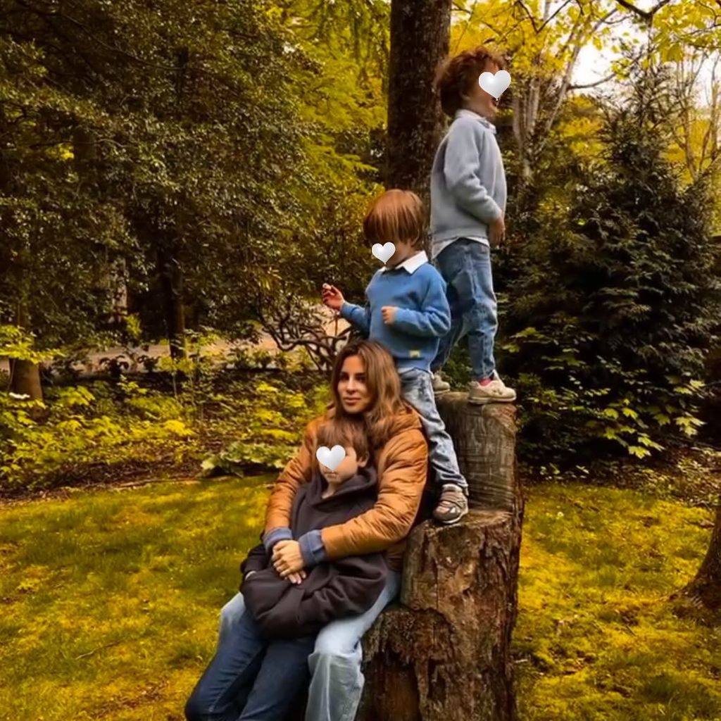 alejandra silva sitting on tree trunk with three sons