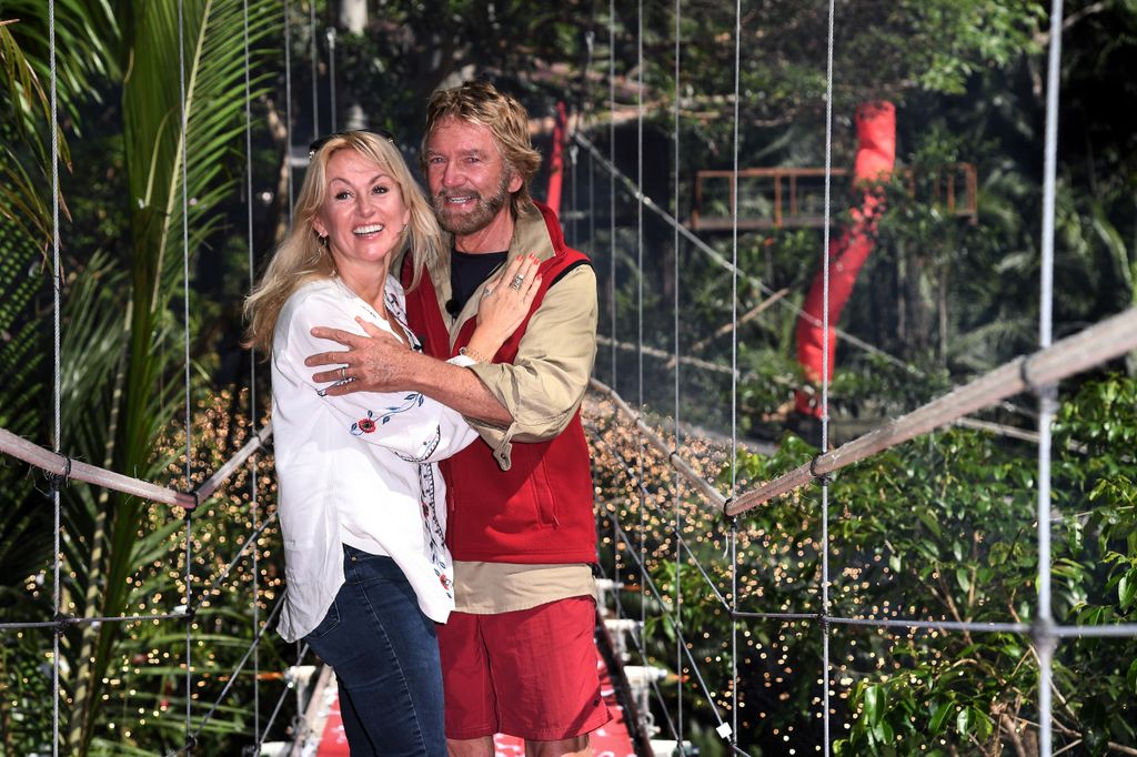 Liz and Noel Edmonds embracing on a wodden bridge