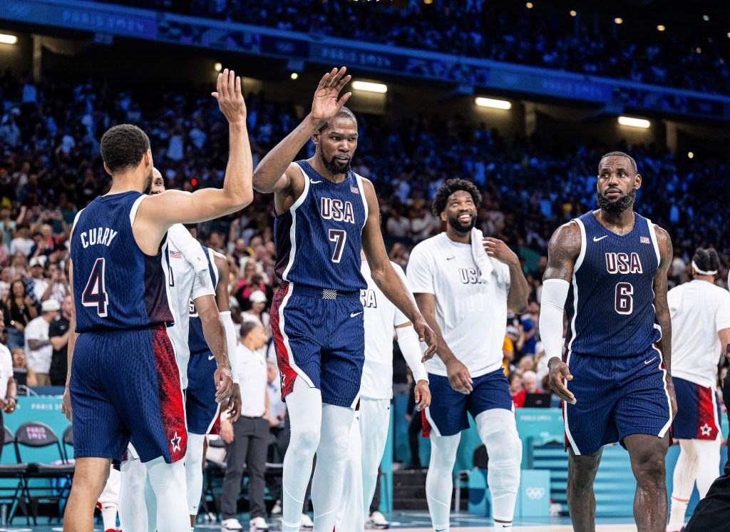 LILLE, FRANCE - JULY 28: Stephen Curry, Kevin Durant and LeBron James (L-R) of USA celebrates victory while the group stage match between Serbia and USAon day two of the Olympic Games Paris 2024 at Stade Pierre Mauroy on July 28, 2024 in Lille, France. (Photo by Markus Gilliar - GES Sportfoto/Getty Images)
