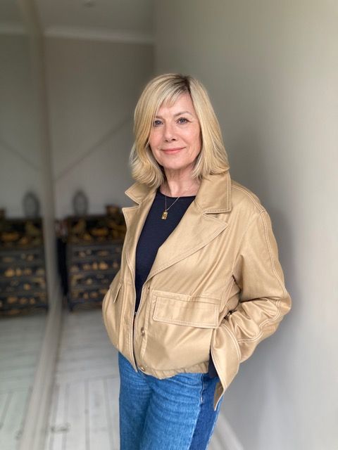 glynis barber smiling in a cropped trench coat