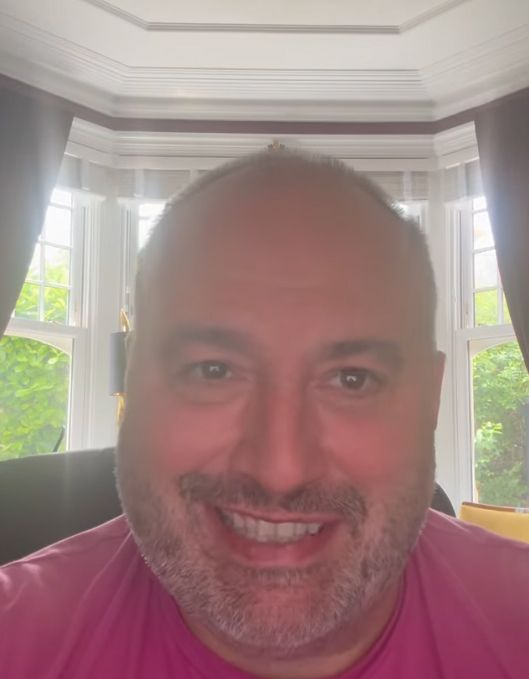 Wynne Evans grinning inside a living room