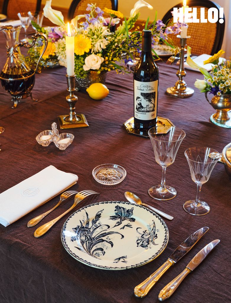 The dining table decorated with colourful flower sprays, canles and plates with a floral pattern in the  Château Toulouse-Lautrec