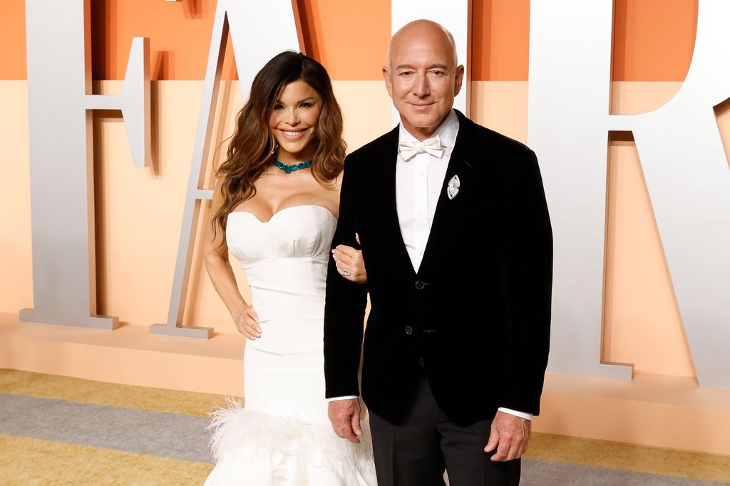 Lauren Sanchez and Jeff Bezos link arms on red carpet at Vanity Fair Oscars party