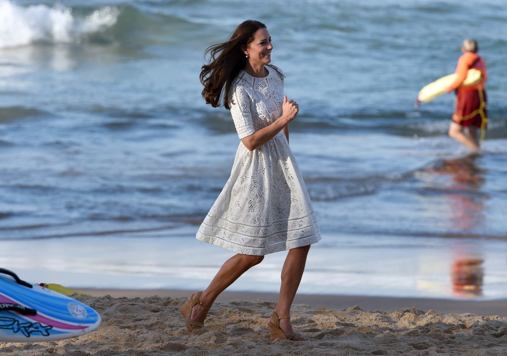 kate running along beach in dress