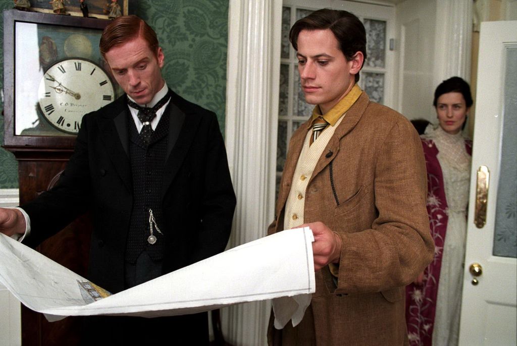 two men looking at housing plans in Victorian-era clothing
