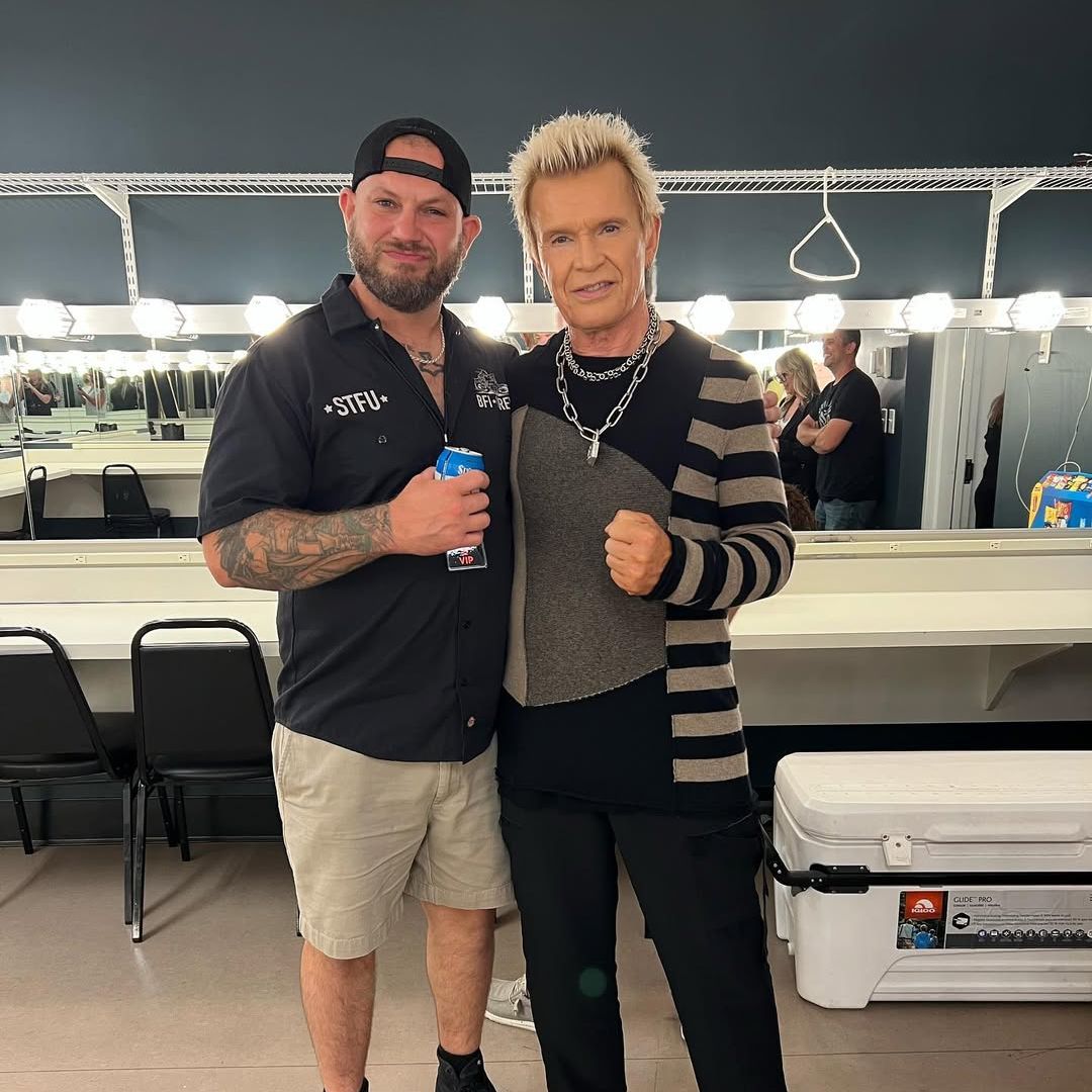 Billy Idol and his son Brant Broad pose for a photo backstage at a concert, shared on Instagram