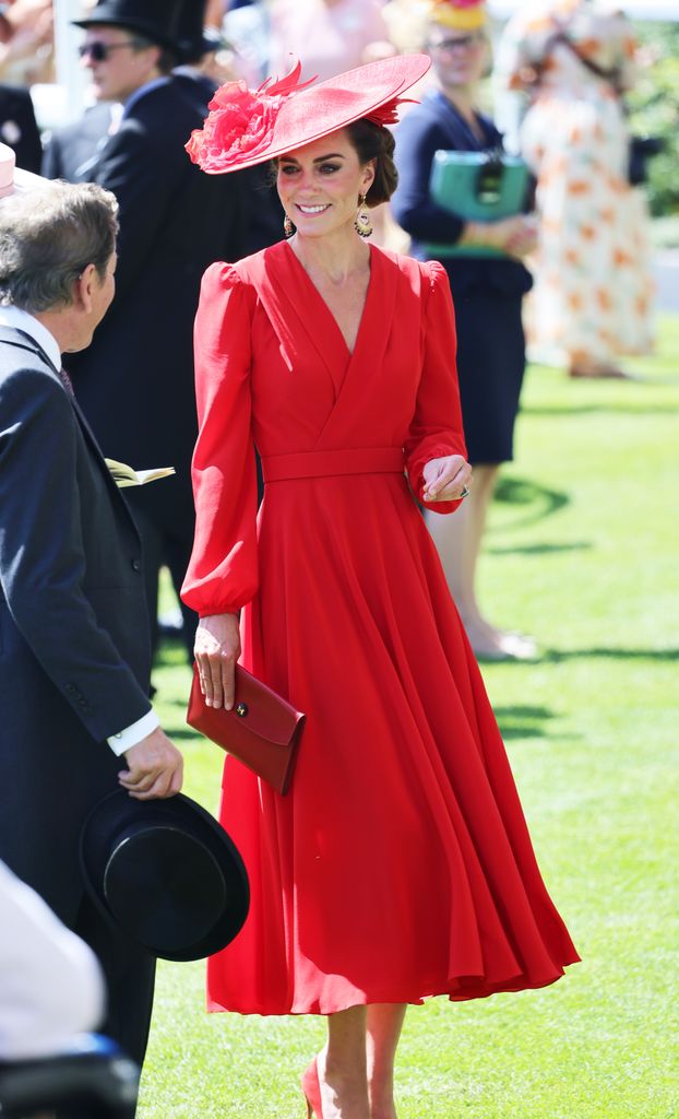 Kate Middleton wearing a red Alexander McQueen tea-length dress with long sleeves, a wide-brimmed matching hat, and red accessories at Royal Ascot.