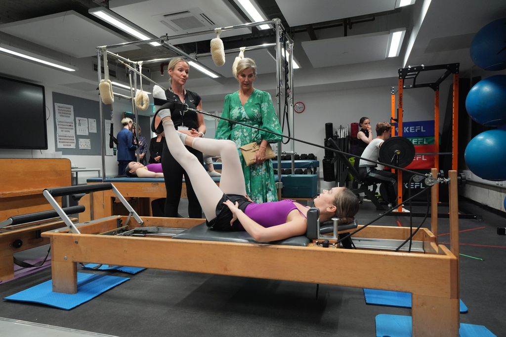 The Duchess of Edinburgh observing girl using gym equipment