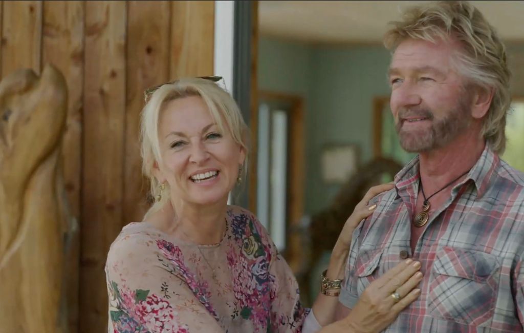 Liz and Noel Edmonds outside a wooden house