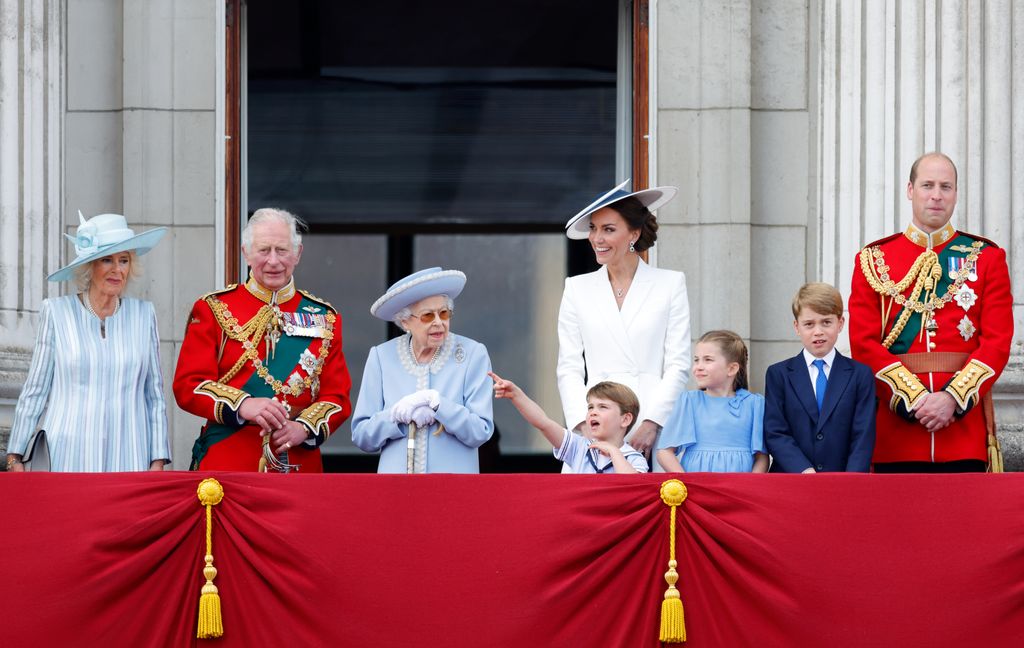 Camilla, Duchess of Cornwall, Prince Charles, Prince of Wales (wearing the uniform of Colonel of the Welsh Guards), Queen Elizabeth II, Prince Louis of Cambridge, Catherine, Duchess of Cambridge, Princess Charlotte of Cambridge, Prince George of Cambridge and Prince William, Duke of Cambridge stood on the balcony watching a flypast