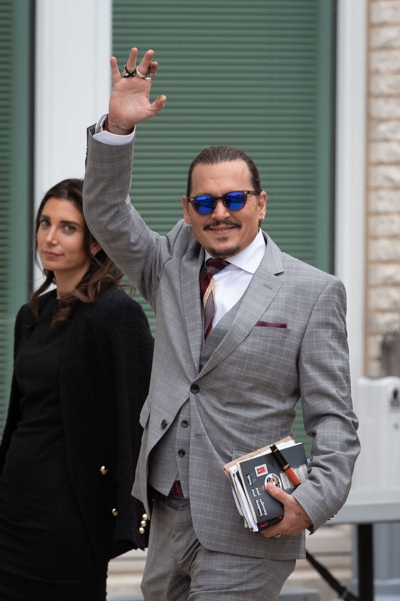 Johnny Depp waves to his fans as he walks outside court during the Johnny Depp and Amber Heard civil trial at Fairfax County Circuit Court on May 26, 2022 i