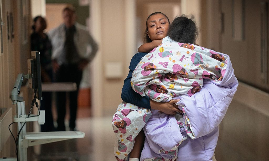 woman carrying child wrapped in duvet in hospital 