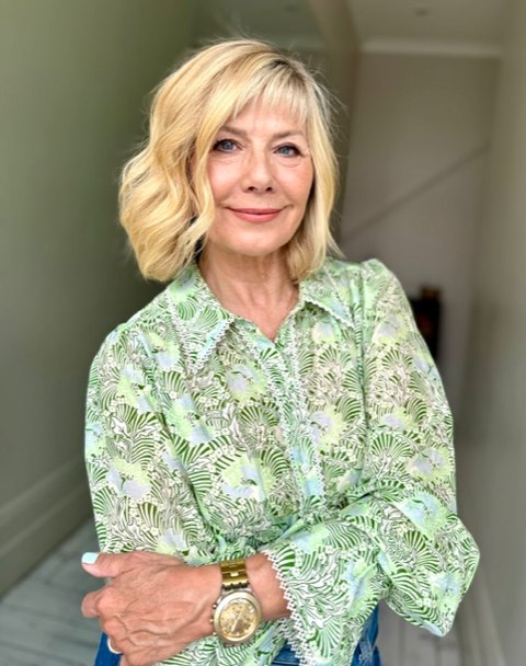 Smiling blonde woman in a printed green shirt