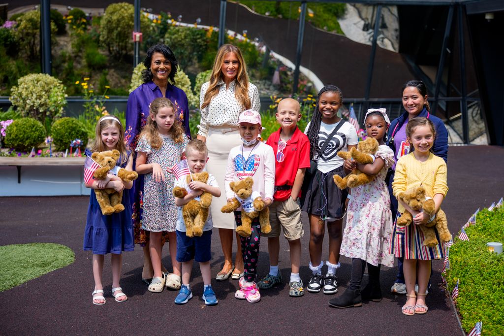 Melania Trump, accompanied by Children's National Hospital President and CEO Michelle Riley-Brown (L), poses for a photograph with children in the the Bunny Mellon Healing Garden at Children's National Hospital