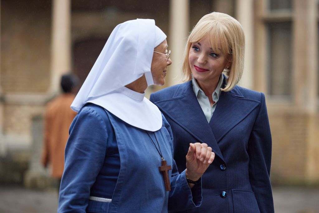 woman in nun's habit and blonde woman in blue suit