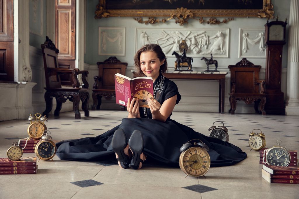 Young woman sitting on the floor holding a book