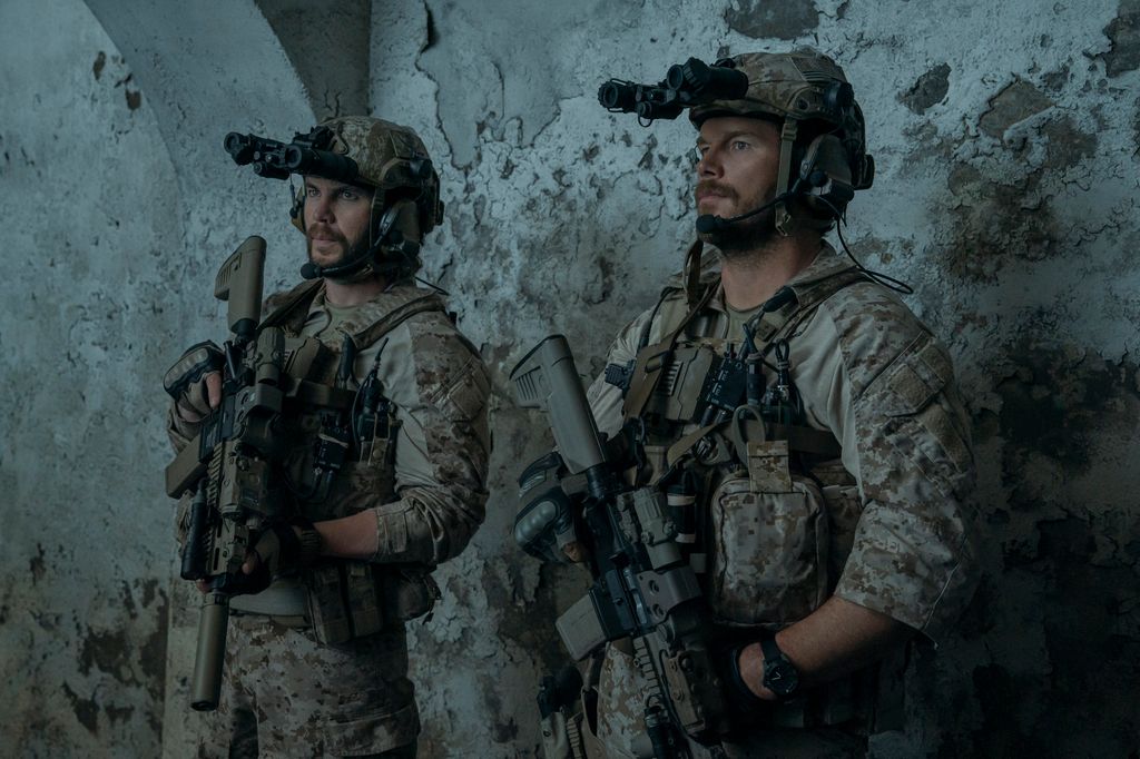 two men in military gear holding guns