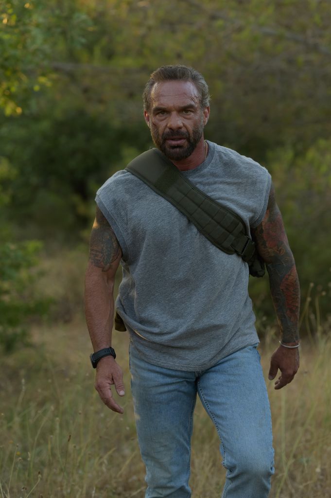 man walking through grass