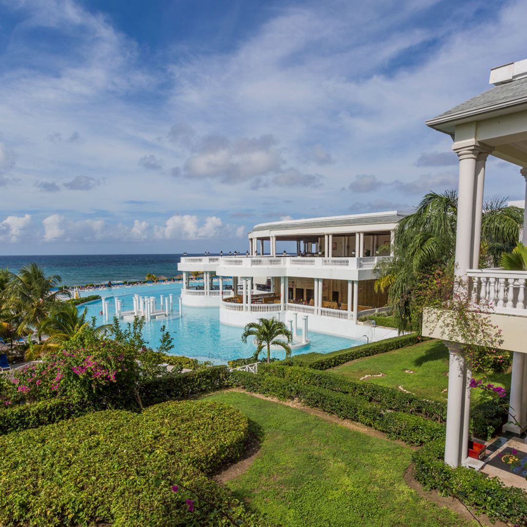 outdoor pool with balconies and ocean in background in Jamaica