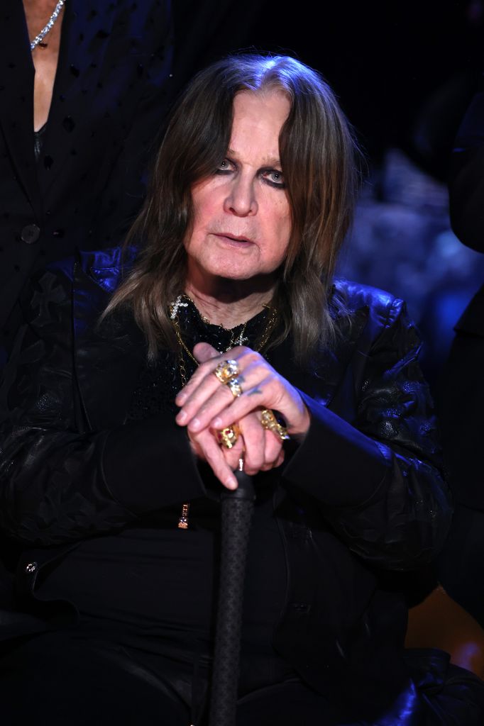 Ozzy Osbourne in a black outfit with rings