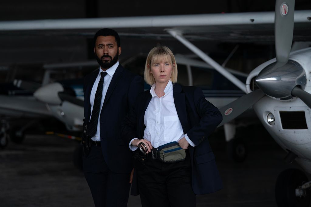 man and woman in suits standing beside planes