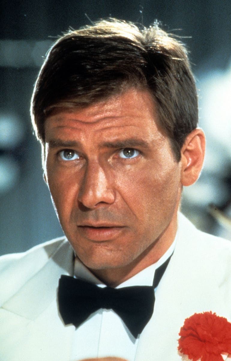 Harrison Ford in a near-identical tuxedo with a red carnation.