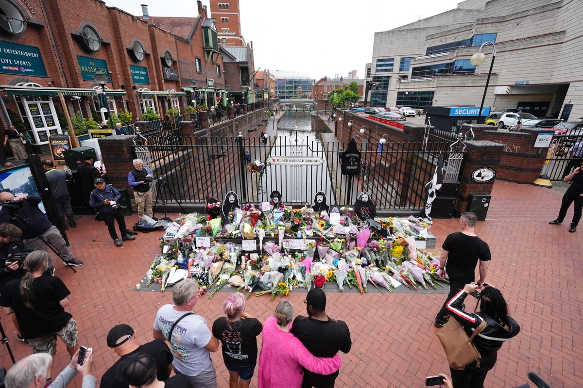 Fans gather at Black Sabbath Bridge in Birmingham to honor Ozzy Osbourne, leaving flowers, messages, and tributes at a growing memorial for the rock legend.