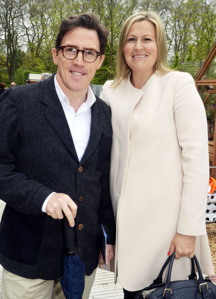 man and woman posing for photo outdoors