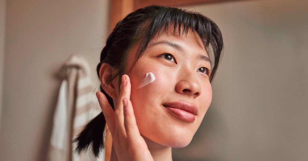 woman applying cream to her face