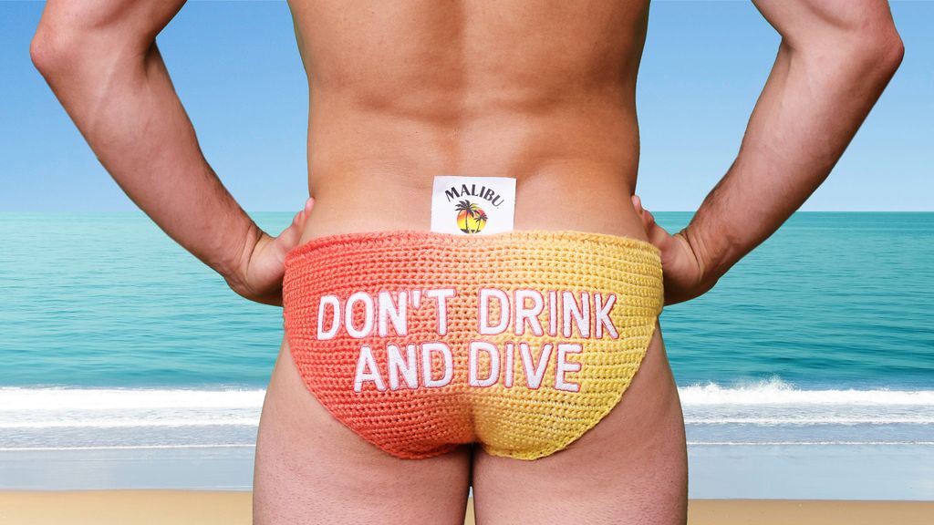 The rear of Tom Daley in a pair of yellow and coral trunks with the message 'Don't Drink and Dive'