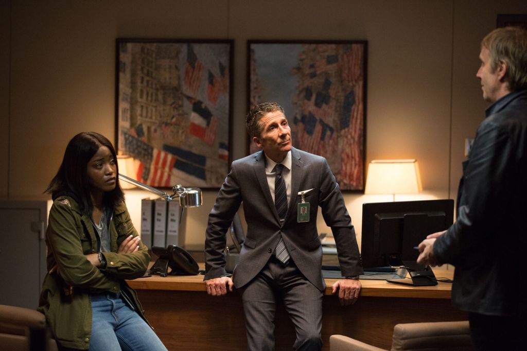 three people talking in dimly-lit office