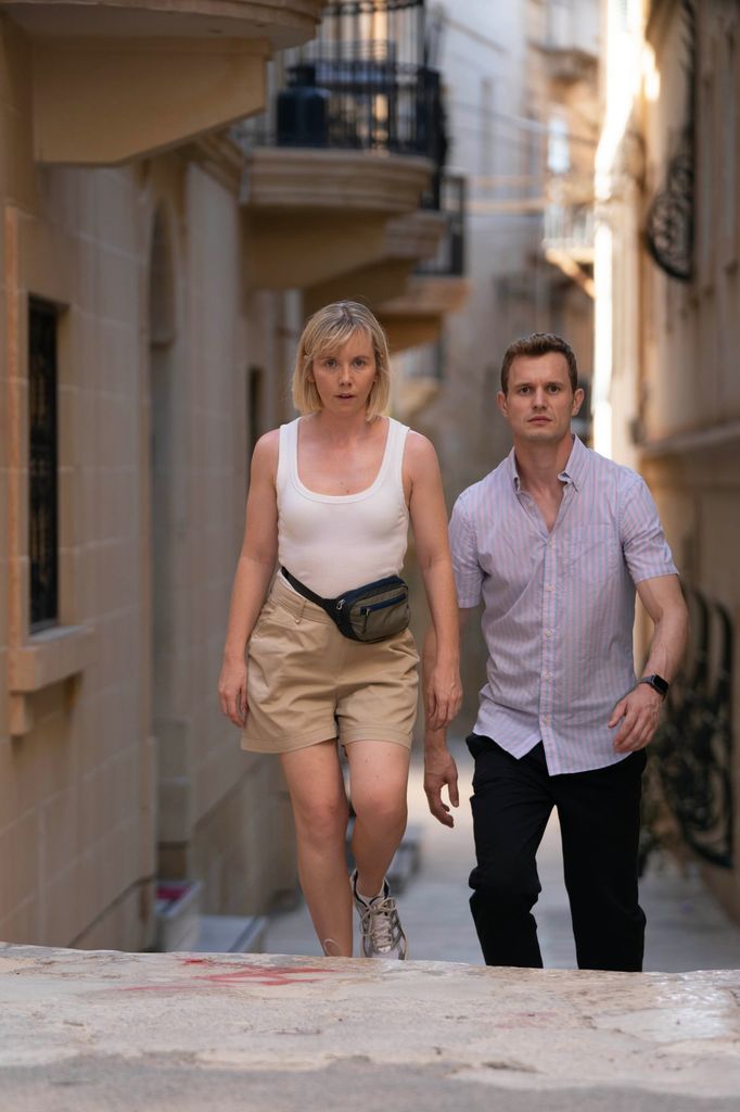 woman and man walking down narrow street