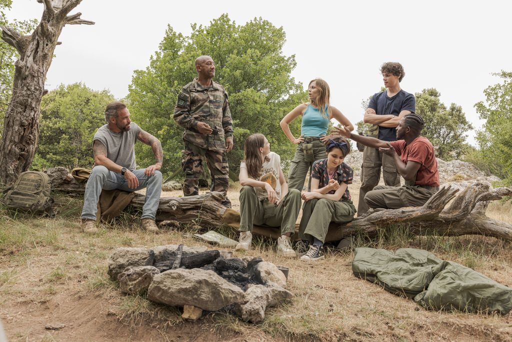 group of people sitting on tree log