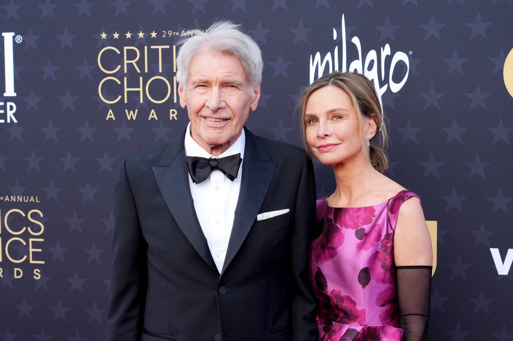 Harrison Ford and Calista Flockhart look at camera while walking on red carpet of critics choice awards