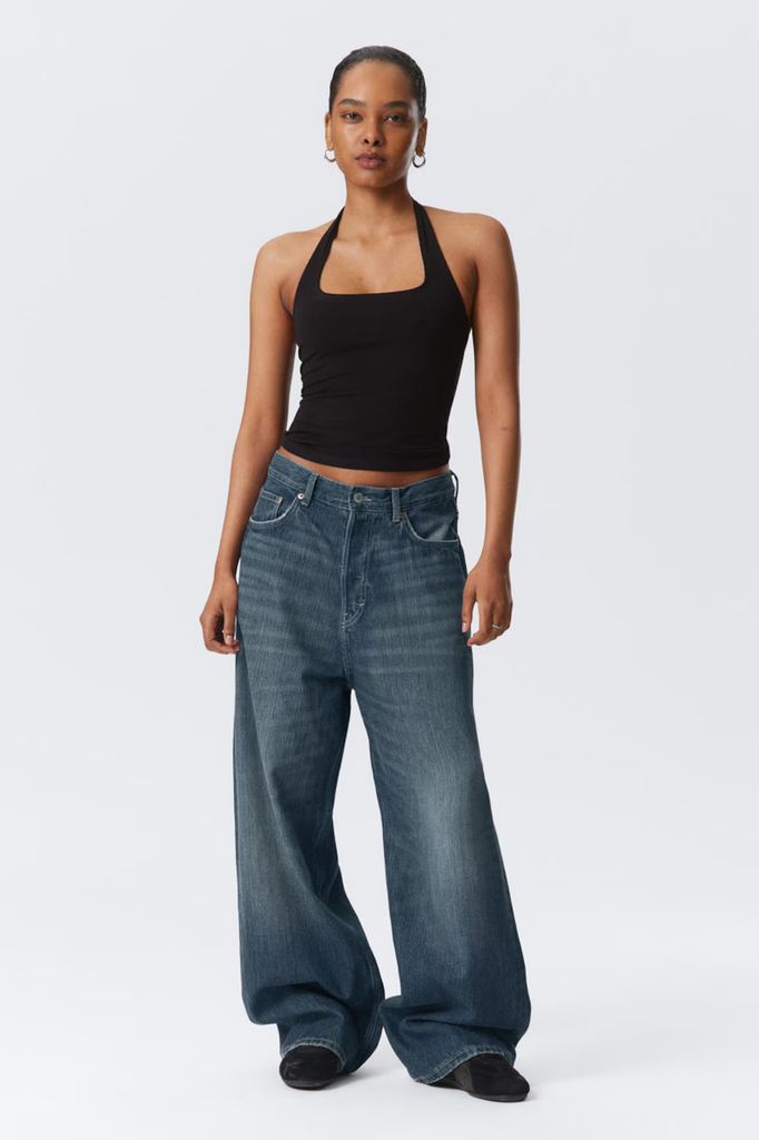 model in baggy jeans and black tank top