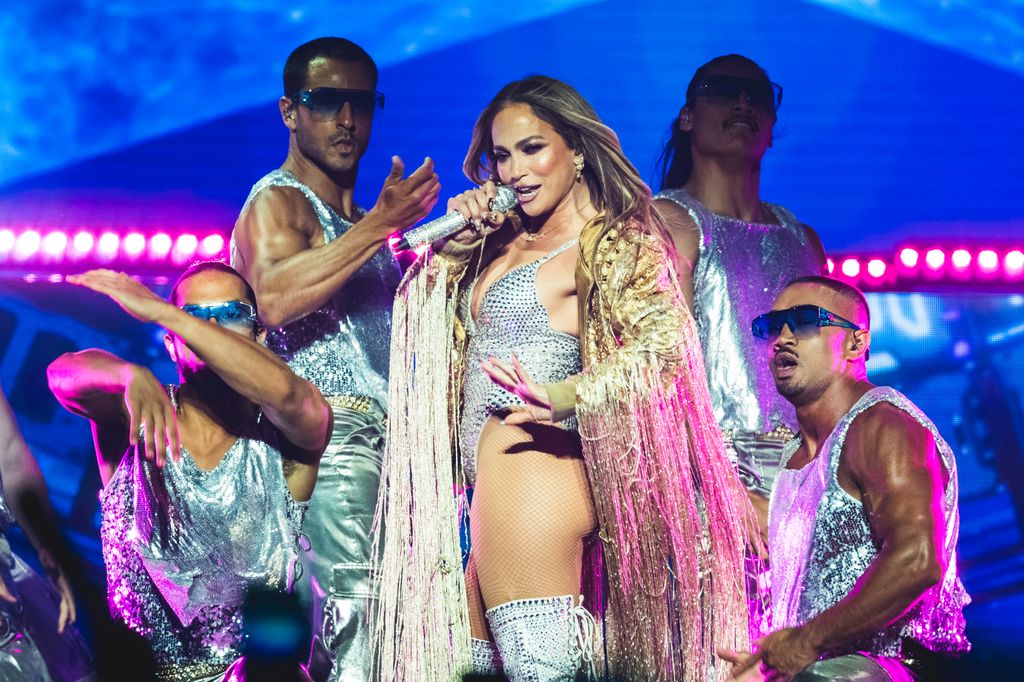 Jennifer Lopez performing in silver bodysuit and thigh-high boots on Up All Night Tour