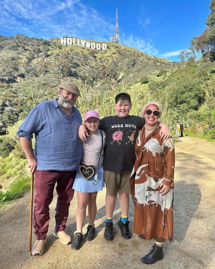family-of-four posing near hollywood sign