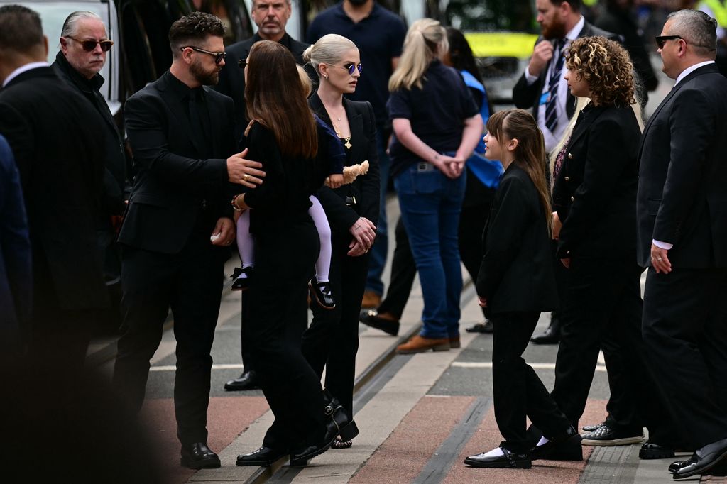 The family of Ozzy Osbourne: son Jack Osbourne (2L) is with wif Aree and daughter Maple, as daughter Kelly Osbourne (C) looks towards Jack's girls Andy and Pearl 