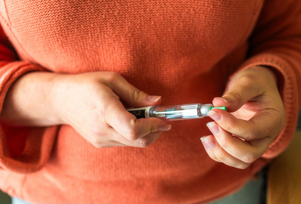 Woman preparing to administer weight loss injection