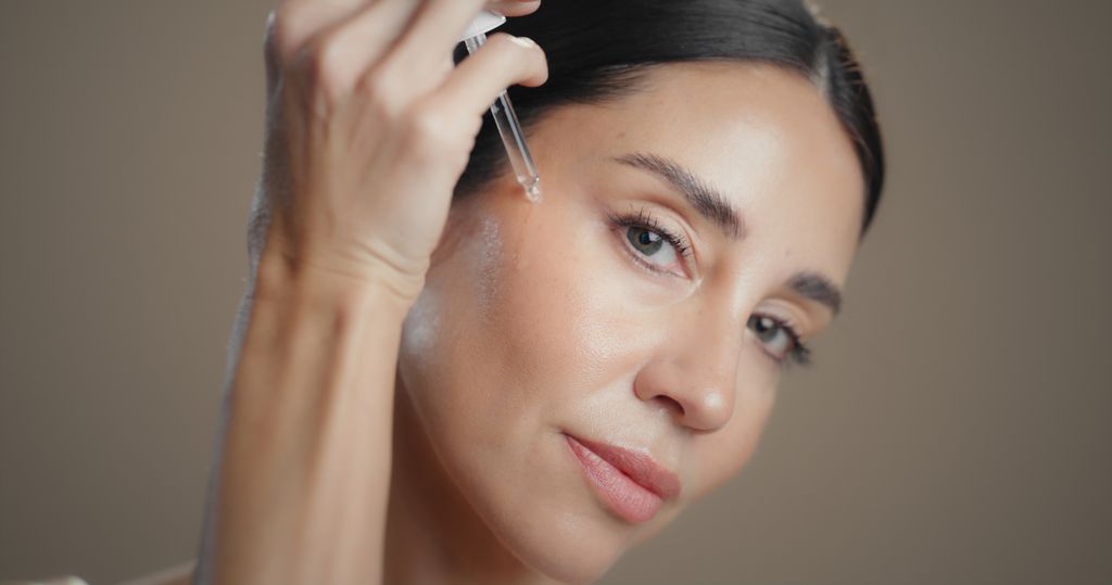 woman applying serum to her face