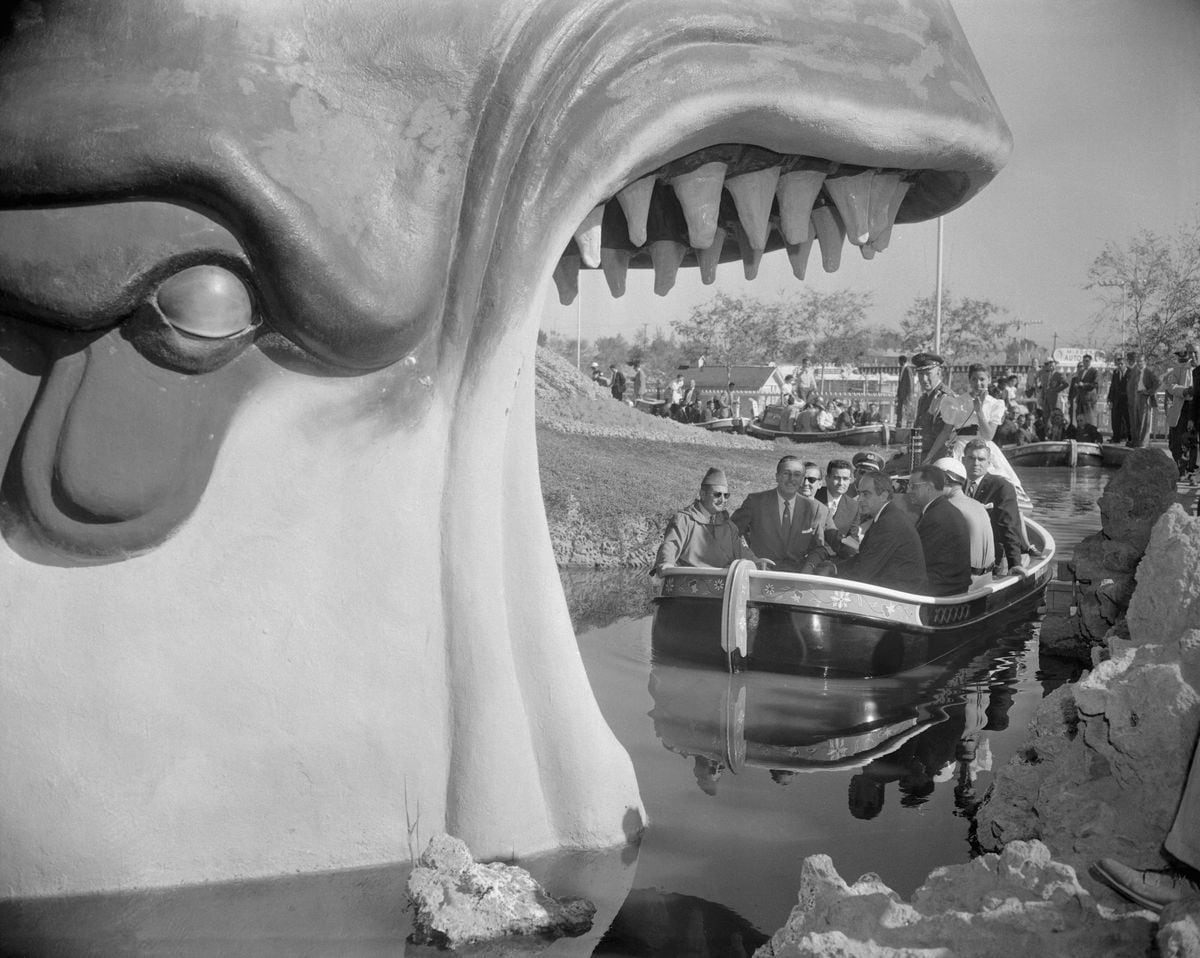 (Original Caption) Ready to be swallowed up by the whale in Disneyland is King Mohammed V, of Morocco (left, foreground), in boat, during his tour of the famous land of make believe. His host, Walt Disney, is seated next to the king.