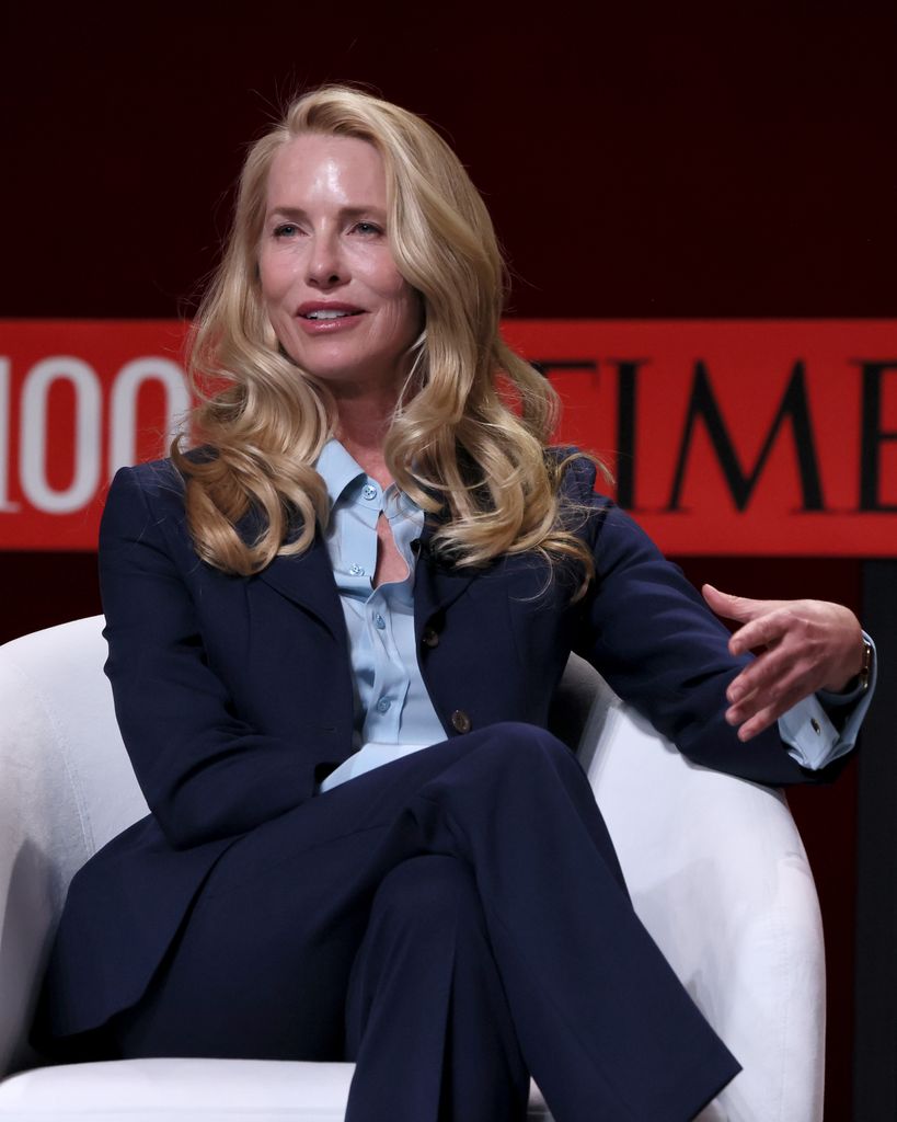 laurene powell jobs in navy suit sitting on white chair