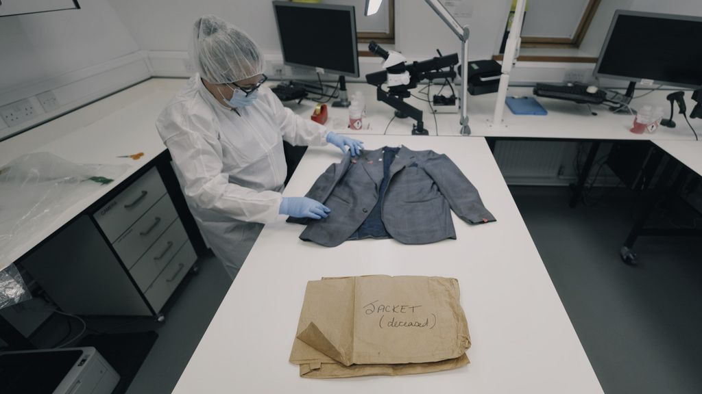 woman in white forensic coat examining blazer