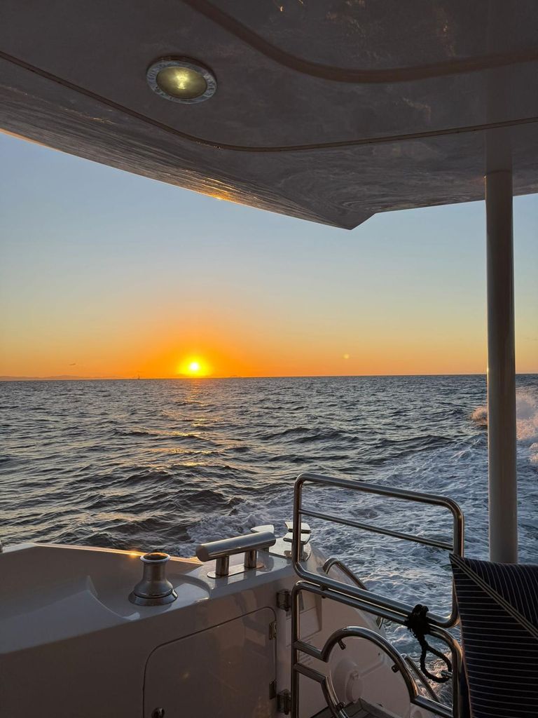 sunset over the sea from the side of a boat