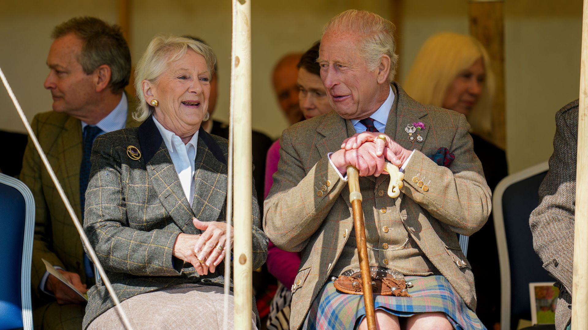 King Charles speaking with a woman, Lady Sarah Chatto sits behind him
