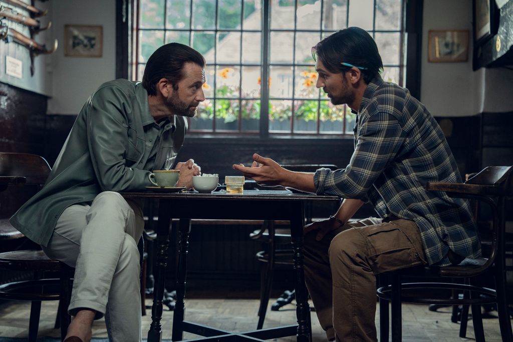 David Tennant sat across a table from Henry Lloyd-Hughes in The Thursday Murder Club 