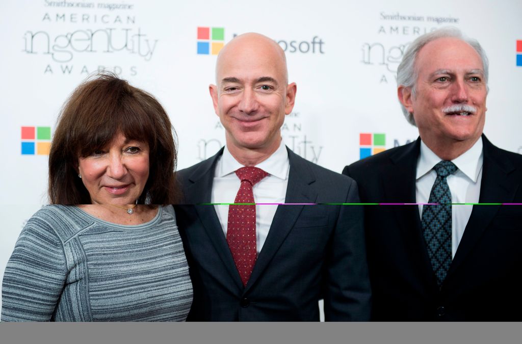 Amazon CEO Jeff Bezos poses on the red carpet with his parents Mike and Jackie